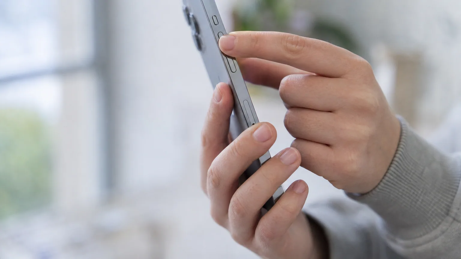 Mains tenant un smartphone et appuyant sur les boutons latéraux pour faire une capture d'écran