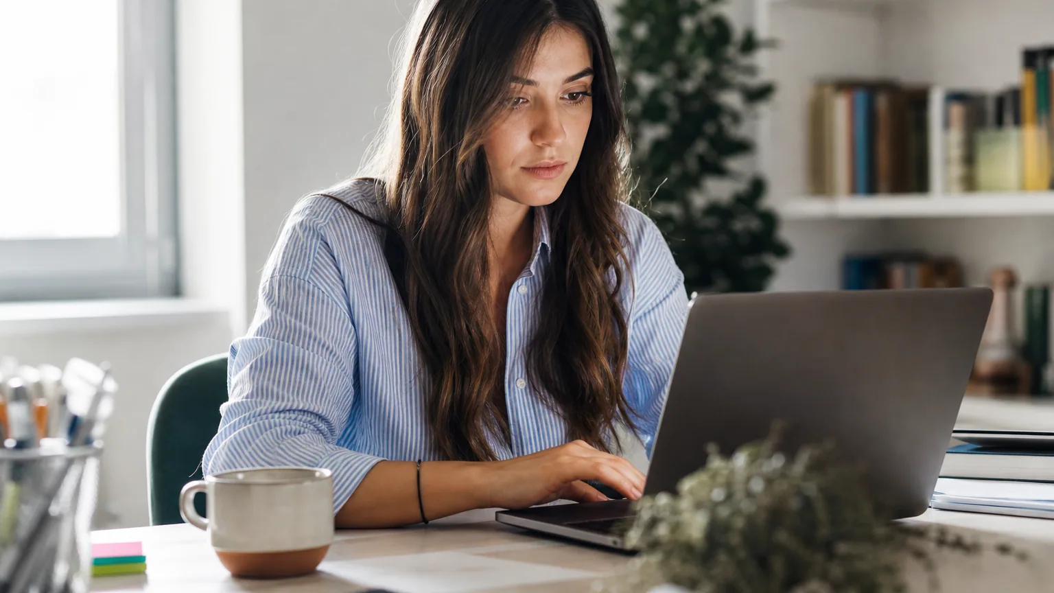 Une femme utilise un assistant d'intelligence artificielle sur son ordinateur portable à son bureau