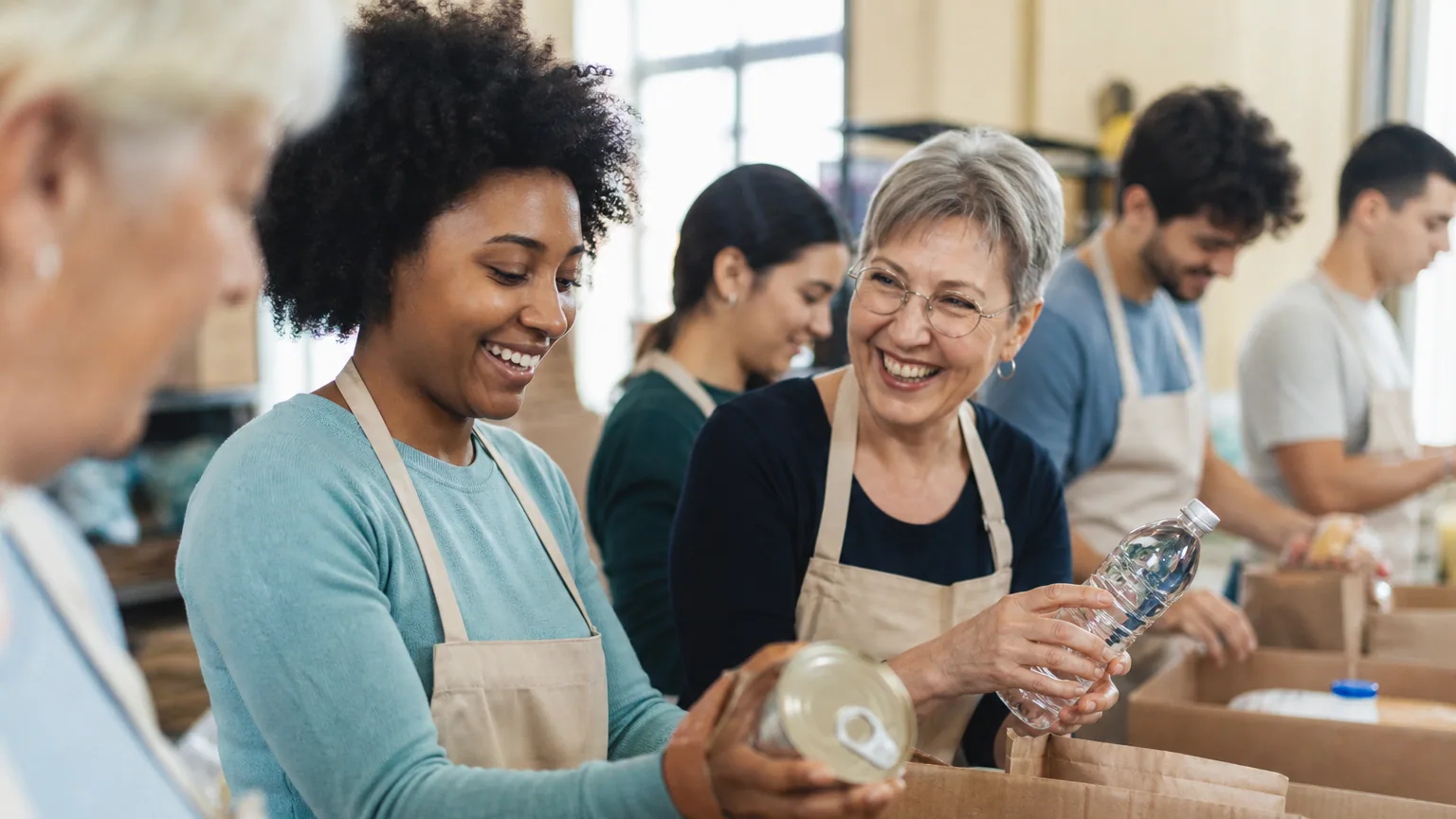 Des bénévoles trient ensemble des dons alimentaires dans un local associatif lumineux.