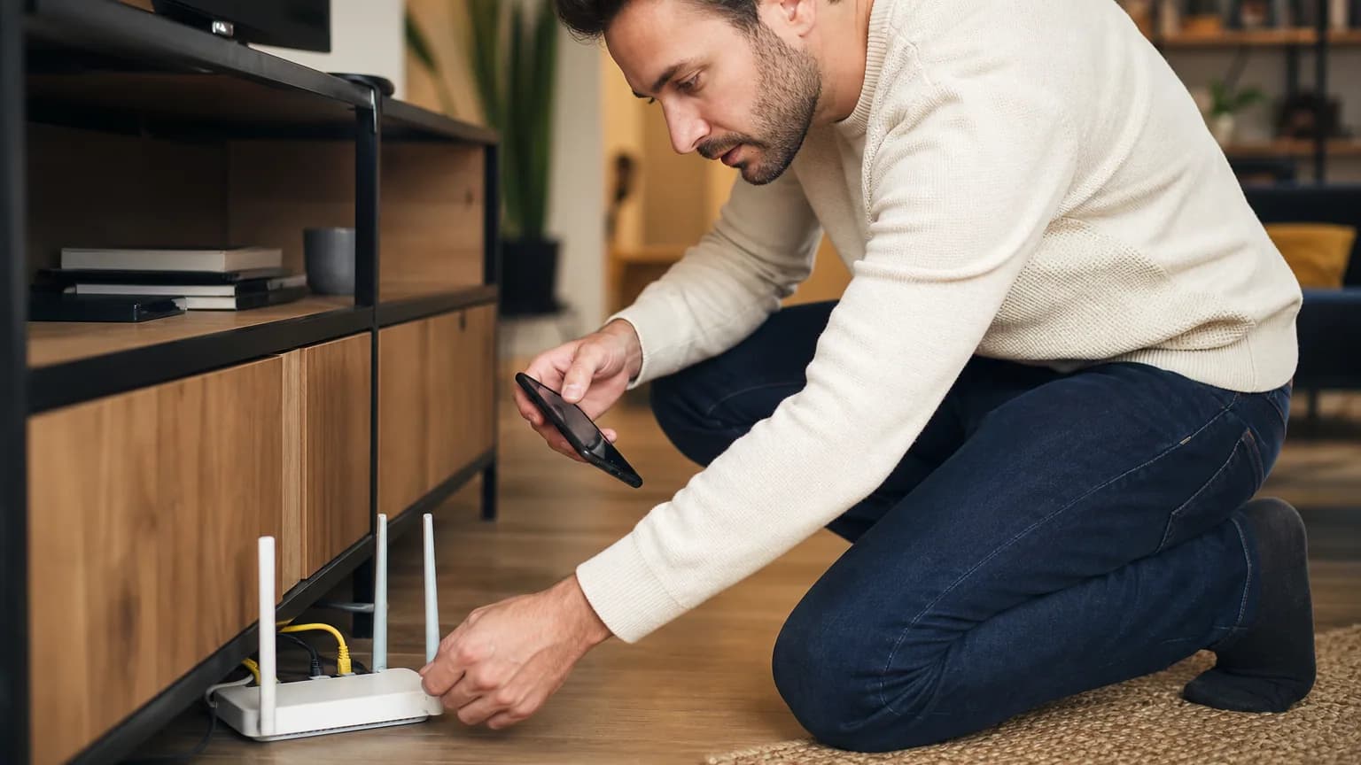 Une personne configure les réglages de sa box internet à domicile avec son smartphone